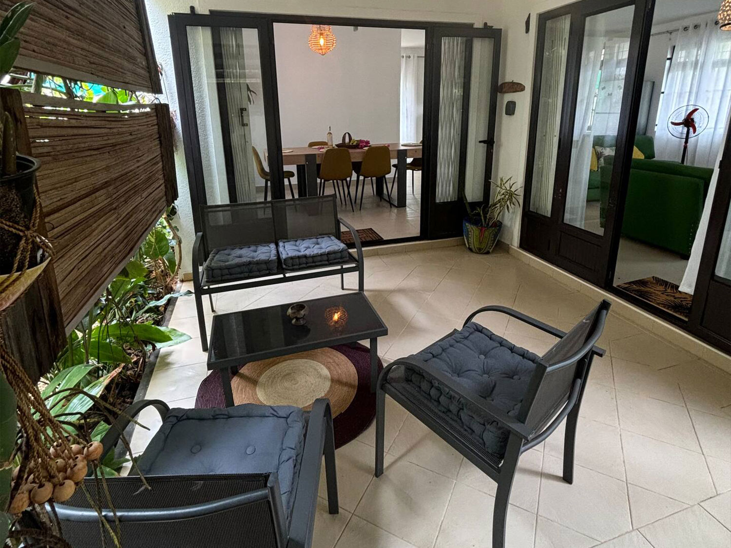 Terrasse abritée dans le jardin tropical de la Villa Coco Zen, parfaite pour se détendre à l’ombre