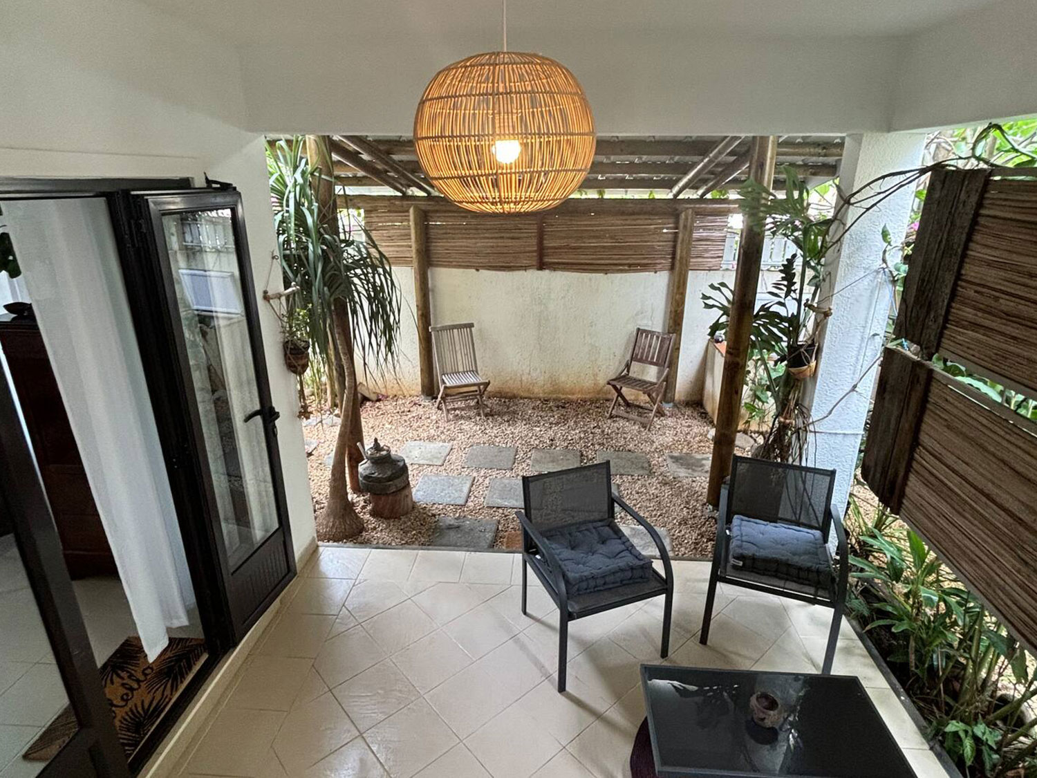 Terrasse abritée dans le jardin tropical de la Villa Coco Zen, parfaite pour se détendre à l’ombre