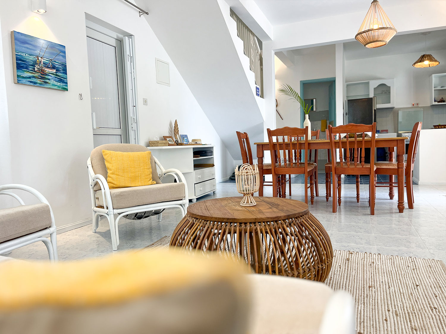 Salon décoré dans le style créole avec canapé et espace repas à Lakaz Tropikal